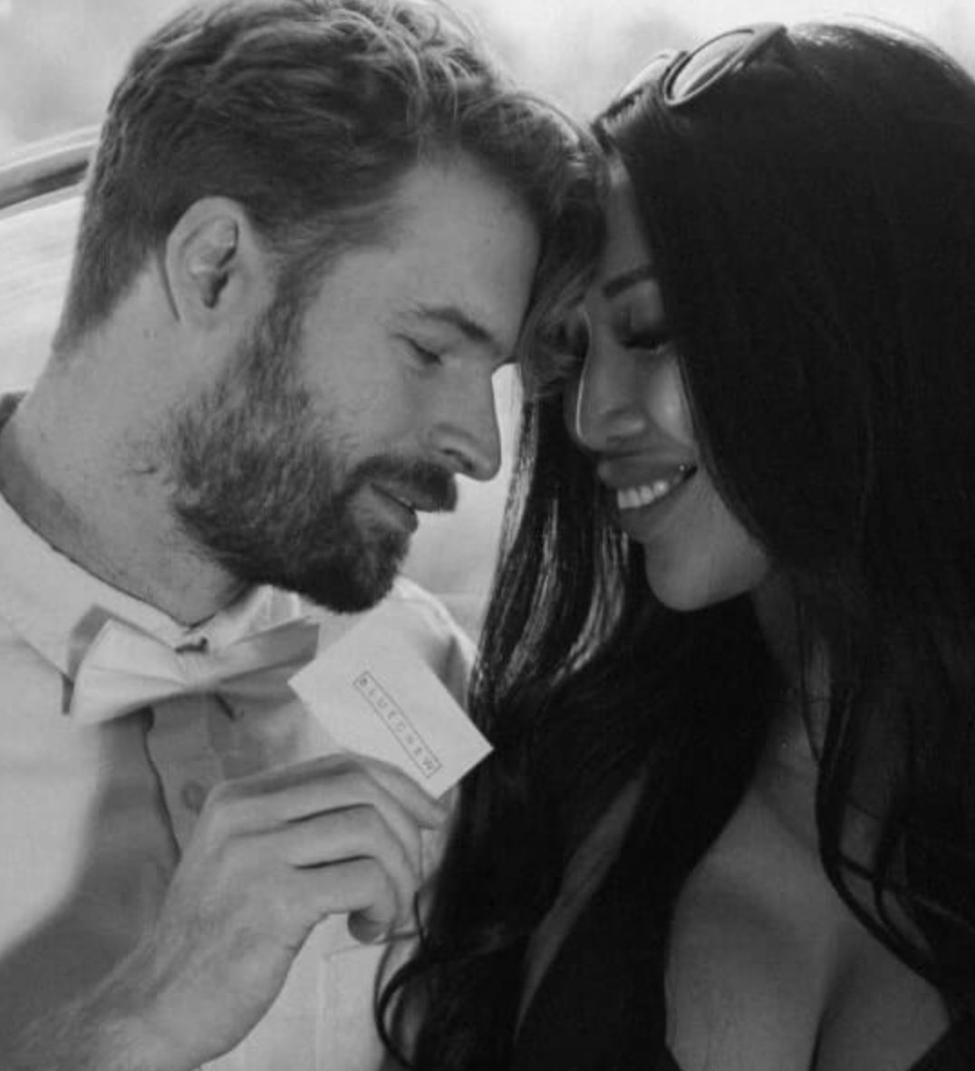 A couple sharing an intimate moment, looking into each other's eyes while the man holds a BlueChew packet, indicating BlueChew's improvement in their sex life.