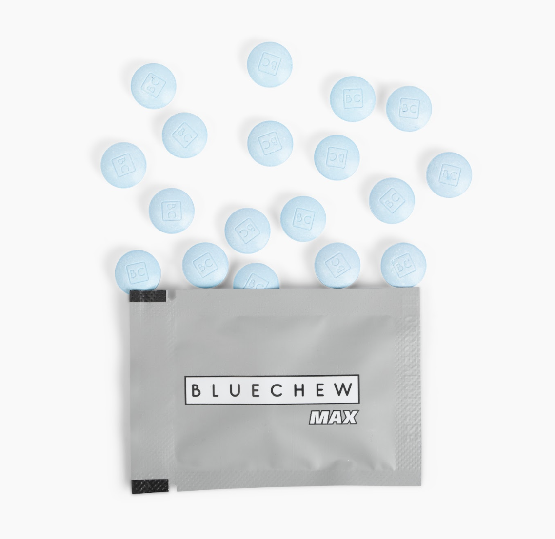 A packet of BlueChew MAX tablets with a few tablets scattered around, featuring a light blue color and embossed branding.