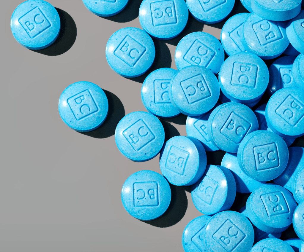 A close-up of bluechew chewable tablets with 'BC' imprinted on them, which can help improve erections in men with diabetes